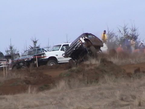 1994 Ford Explorer - Multiple vehicles tackle a challenging muddy course during an off-road event.