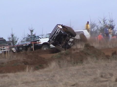 1994 Ford Explorer - An off-road vehicle is stuck in the mud during an event, with spectators and other vehicles in the background.