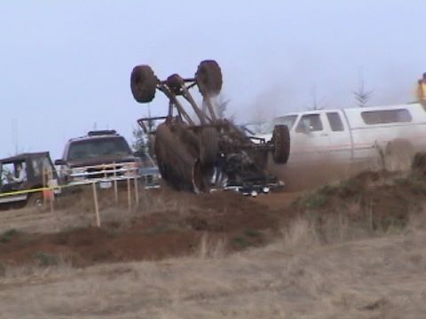 1994 Ford Explorer - An off-road vehicle has rolled over in the mud, with other vehicles present at the scene.