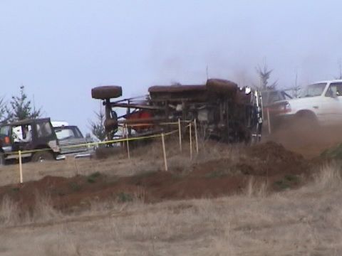 1994 Ford Explorer - A vehicle has overturned during an event, with other vehicles present in the background.
