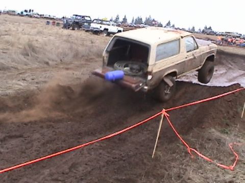 1994 Ford Explorer - SUV navigates a muddy course during an event, with other vehicles visible in the background.