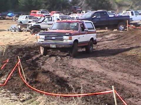 1994 Ford Explorer - Ford Bronco navigating a muddy obstacle course during an event.