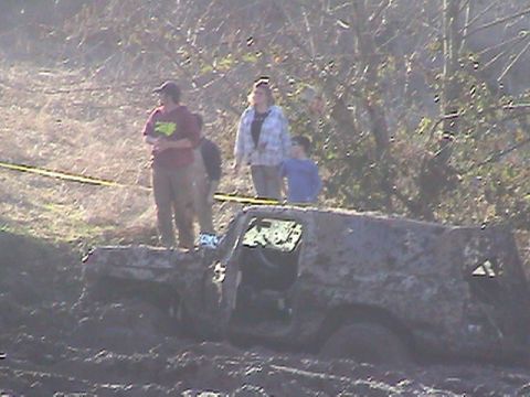 1994 Ford Explorer - This mud-covered SUV appears to be from the early 1990s, not a 1994 model, as it is stuck in the mud.