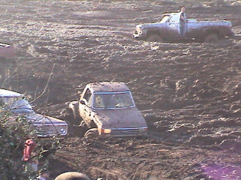 1994 Ford Explorer - Multiple vehicles are stuck in deep mud during an event.
