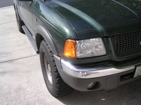 1985 Ford Bronco - A green Ford Ranger pickup truck is shown from the front corner, highlighting its chrome bumper and grille.
