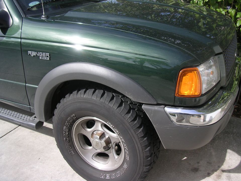 Green Ford Ranger pickup truck front fender, wheel, and bumper