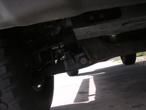 1985 Ford Bronco - The photo shows the undercarriage of a vehicle, focusing on the suspension components and a tire.