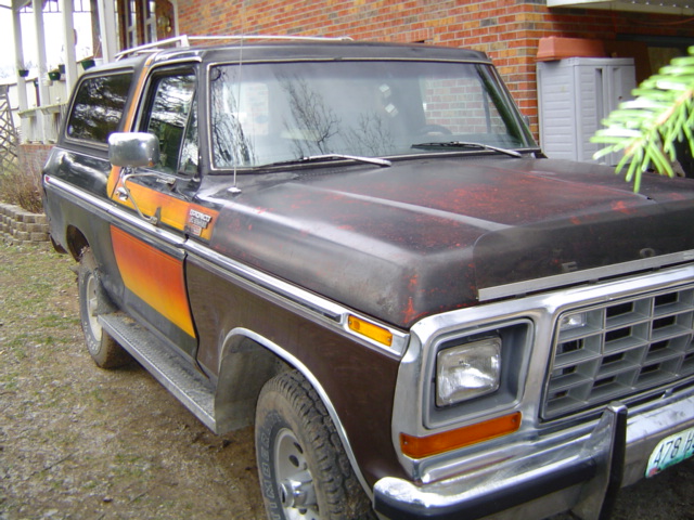 Ford Bronco with a sunset stripe graphic on the side. Hood has some rust spots