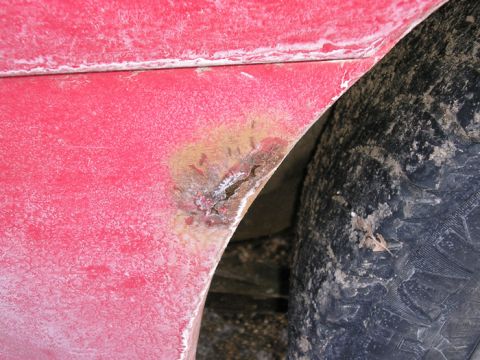 1990 Ford Probe - Close-up view of a vehicle's red fender and tire.