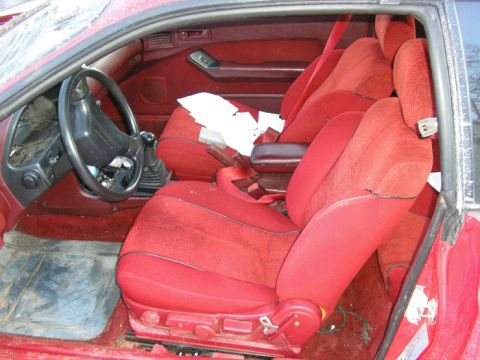 1990 Ford Probe - The interior of the vehicle features bright red seats and a dashboard.