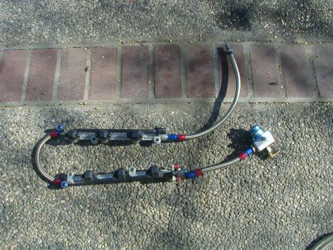 1993 Ford Probe - Fuel rail assembly with injectors and braided lines, likely for an aftermarket engine build.