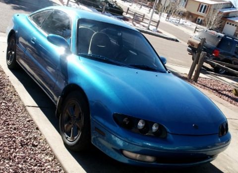 1993 Mazda MX-6 - A blue 1993 Mazda MX-6 coupe is parked on a residential street.