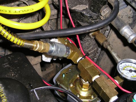 1996 Ford Bronco - On-board air system fittings and gauge, likely installed in a vehicle's engine bay.