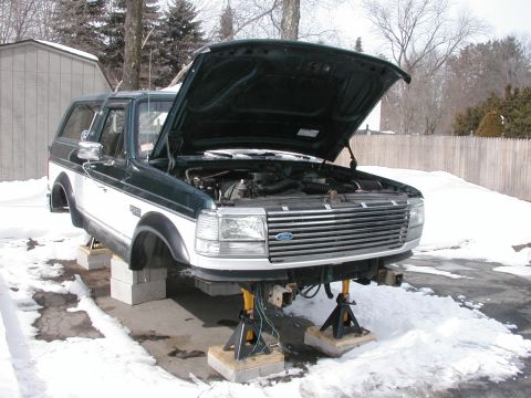 1994 Ford Bronco - This 1994 Ford Bronco is shown with its hood open and front end raised on jack stands, with snow on the ground.