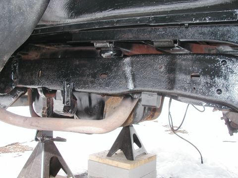 1994 Ford Bronco - Underside view of a vehicle's frame and exhaust system, supported by jack stands.