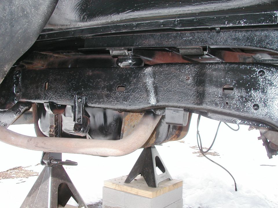 Black painted vehicle frame and exhaust pipe supported by jack stands