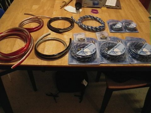 1995 Ford Contour - Various car audio cables and connectors are laid out on a wooden table, ready for installation.