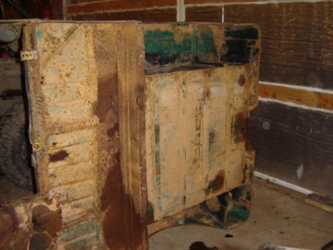 1992 Ford Bronco - This image shows heavily rusted vehicle body panels, with some green and tan paint visible.