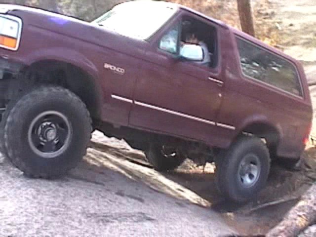 1993 Ford Bronco climbing over rocks on a trail