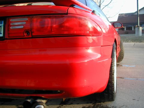 1994 Ford Probe - The rear of a red 1994 Ford Probe is shown, highlighting its distinctive taillight design and body lines.