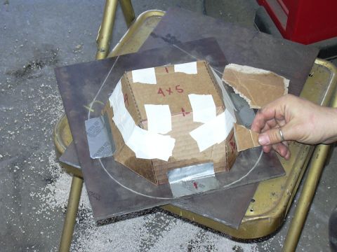 1991 Ford Bronco - A hand steadies a taped-together cardboard mockup marked "4x5" in red, a tapered multi-sided cone pattern, sitting on a sheet of steel plat…