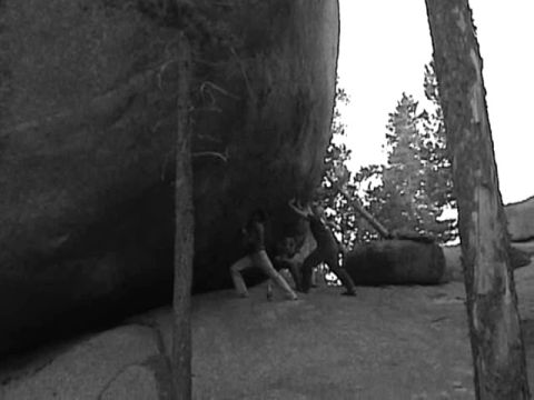 1993 Ford Bronco - People appear to be attempting to move a large boulder in a natural outdoor setting.