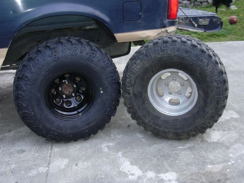 1991 Ford Bronco - Comparing two different off-road tire and wheel setups next to a vehicle's rear fender.