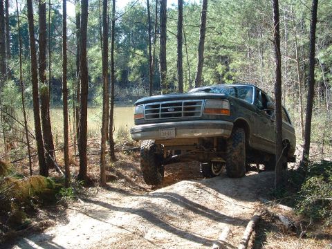 1993 Ford Bronco - This 1993 Ford Bronco navigates a wooded trail with its suspension clearly modified for off-road use.