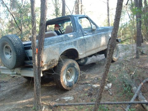 1993 Ford Bronco - This 1993 Ford Bronco is shown navigating a wooded trail, its blue exterior covered in mud.
