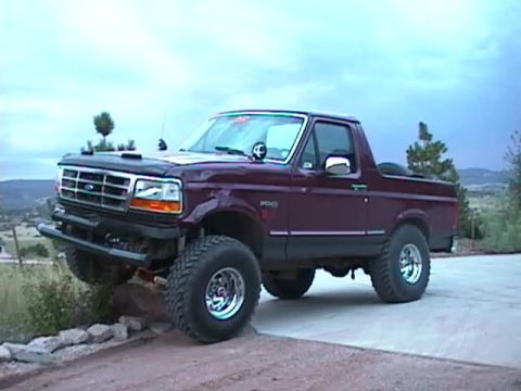 1993 Ford Bronco - This lifted 1993 Ford Bronco is shown in a three-quarter front view, highlighting its off-road capabilities.