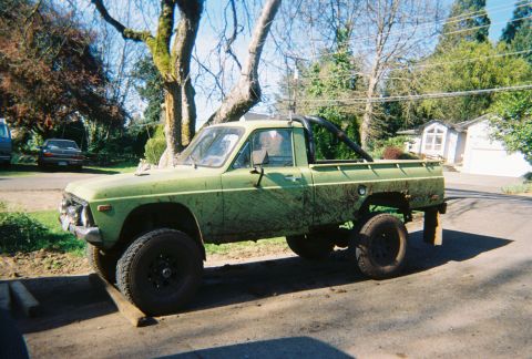1978 Ford Bronco - This lifted green pickup truck features a roll bar and significant mud coverage, suggesting off-road use.