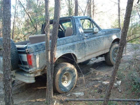 1993 Ford Bronco - This 1993 Ford Bronco is navigating a challenging off-road course in a wooded area.