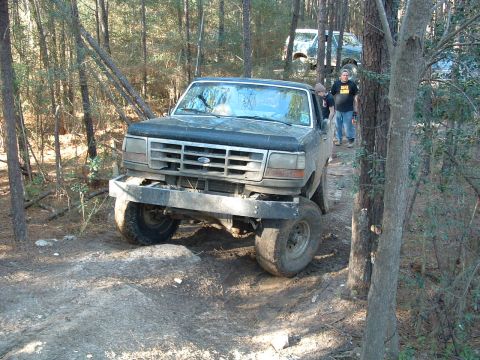 1993 Ford Bronco - Ford Bronco navigating a wooded trail with another vehicle in the background.