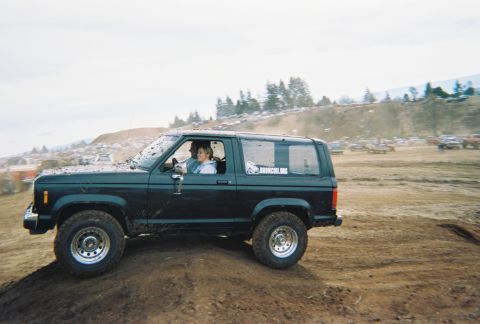 1978 Ford Bronco - A black 1983 Ford Bronco II navigates a muddy terrain with two occupants.