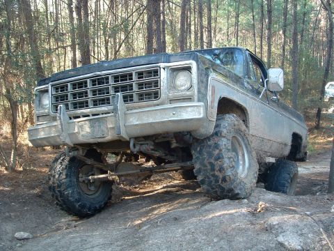 1993 Ford Bronco - This lifted 1973 Chevrolet pickup truck is navigating challenging rocky terrain off-road.