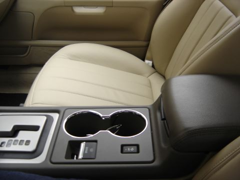 2002 Lincoln Town Car - Interior view of a car's center console and front seats, leather upholstery and cup holders.