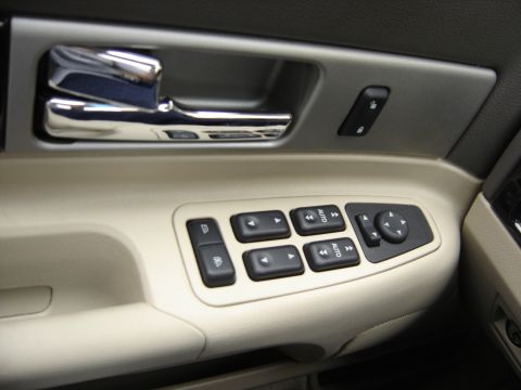 2002 Lincoln Town Car - Close-up of a car's interior door panel, showing the window and mirror controls.