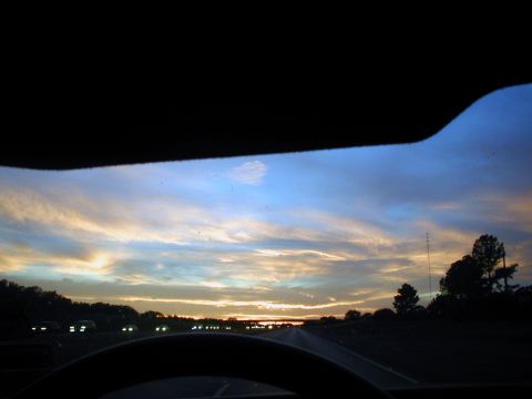 2000 Ford Crown Victoria - Driving on a highway during a colorful sunset, with other vehicles visible ahead.