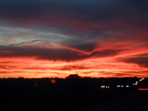 2000 Ford Crown Victoria - Distant headlights visible on the road during a vibrant sunset.