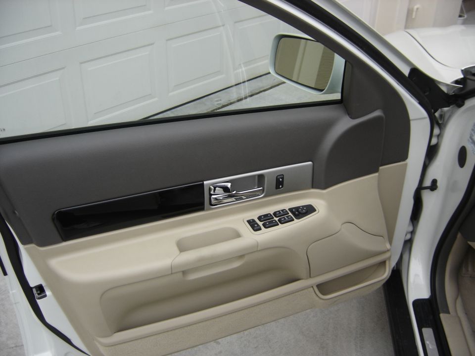 Interior door panel with chrome handle and window controls