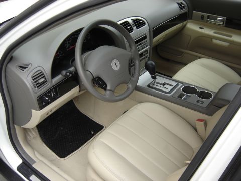 2002 Lincoln Town Car - Interior of a 2002 Lincoln Town Car, light-colored leather seats and wood trim accents.