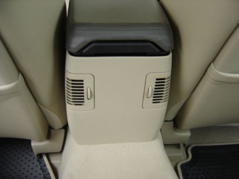 2002 Lincoln Town Car - Interior view of a vehicle's center console, dual air vents and a leather-trimmed armrest.