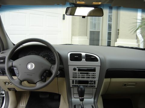 2002 Lincoln Town Car - Interior view of a car's dashboard, steering wheel, and gear shifter, with a garage door in the background.