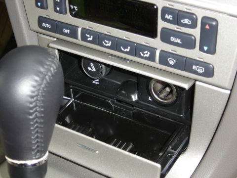 2002 Lincoln Town Car - Interior view of a car's center console, climate controls and a gear shifter.