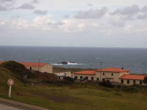 1988 Ford Bronco - Coastal buildings with orange roofs are situated on a hill above the sea.