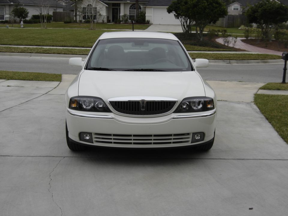 Front view of a white 2002 Lincoln Town Car parked on a driveway