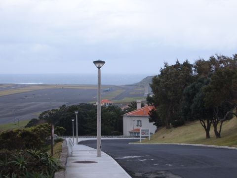 1988 Ford Bronco - A wide view shows an airport runway stretching towards the ocean under a cloudy sky.