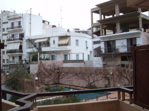 1988 Ford Bronco - A view from a balcony overlooks a courtyard with a pool, surrounded by buildings and an unfinished concrete structure.