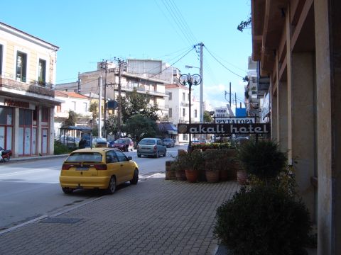 1988 Ford Bronco - A yellow hatchback is parked on the side of a street in a town square.