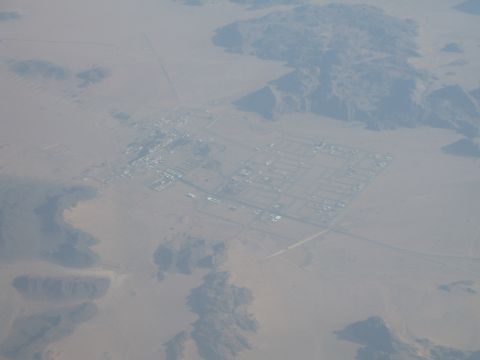 1988 Ford Bronco - An aerial perspective captures a settlement within a vast desert landscape, showing a grid of roads and structures.